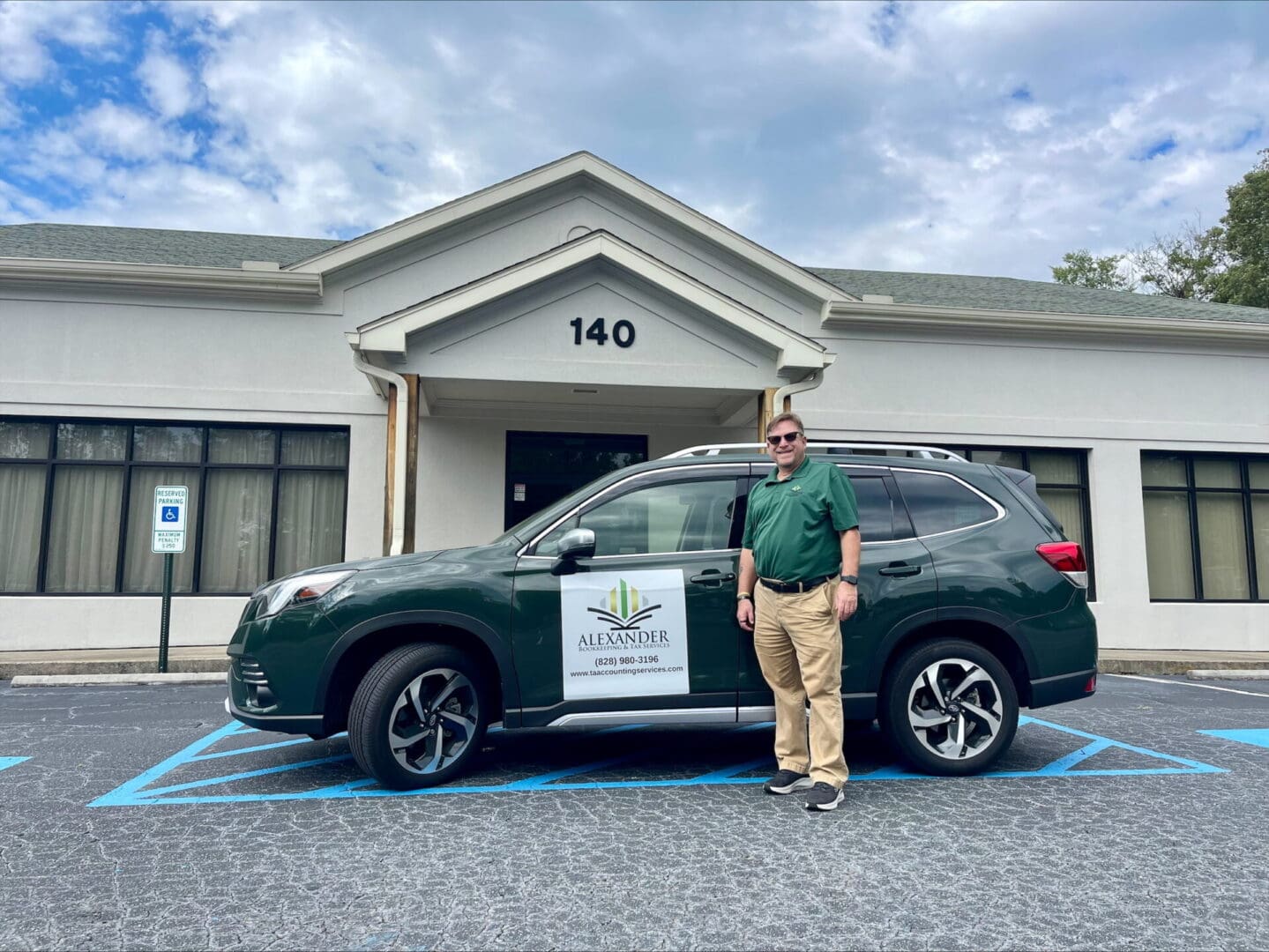 A man standing in front of a green car.